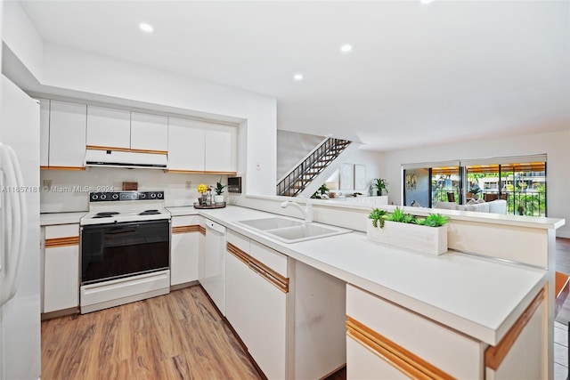 kitchen featuring kitchen peninsula, white appliances, white cabinetry, ventilation hood, and light hardwood / wood-style floors