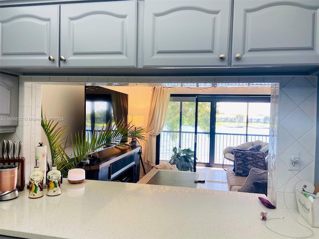 kitchen featuring light stone counters and white cabinetry