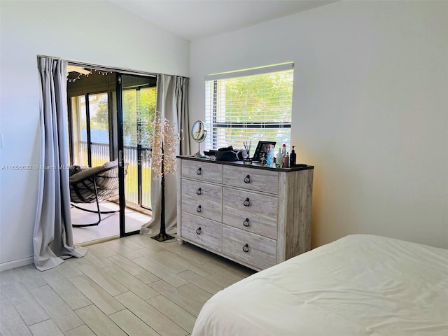 bedroom featuring light wood-type flooring and access to outside