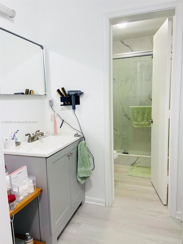 bathroom with vanity, toilet, hardwood / wood-style floors, and walk in shower