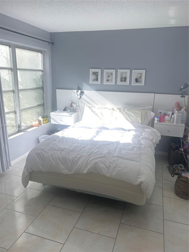 tiled bedroom with multiple windows and a textured ceiling