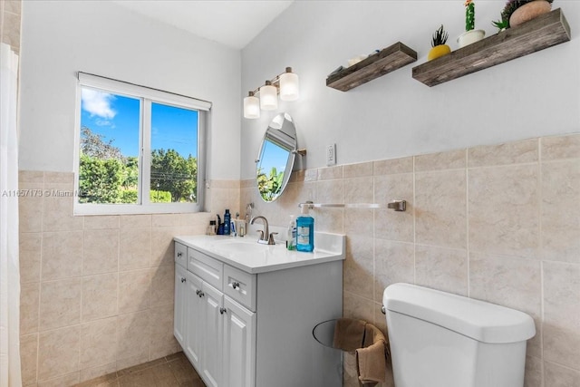 bathroom featuring tile walls, toilet, and vanity