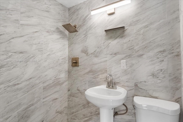 bathroom featuring tile walls and toilet