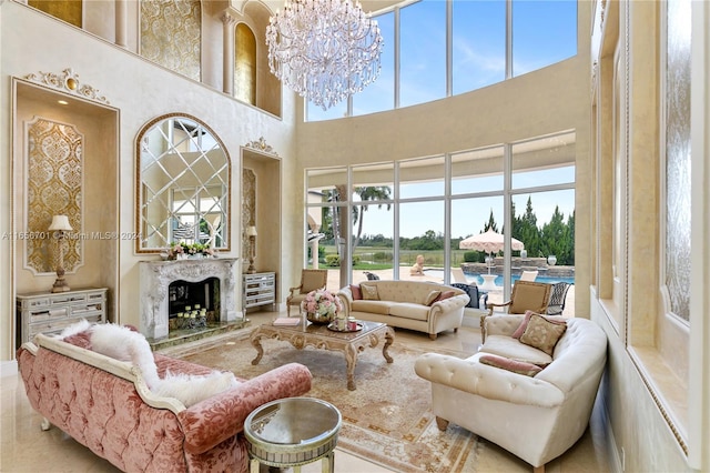 living room featuring a premium fireplace, an inviting chandelier, and a towering ceiling