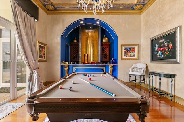 recreation room with billiards, crown molding, wood-type flooring, and a towering ceiling