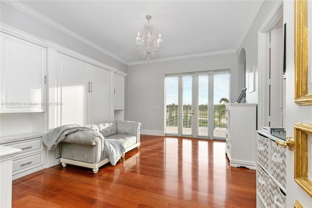 sitting room featuring crown molding, hardwood / wood-style flooring, and a notable chandelier