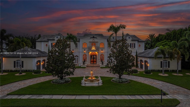 mediterranean / spanish home featuring french doors and a yard