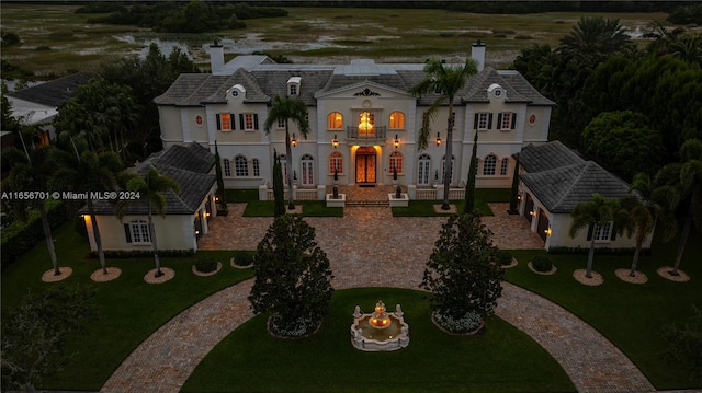 view of front facade with a front lawn and french doors