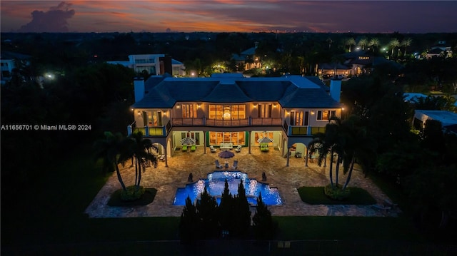 pool at dusk with a patio area