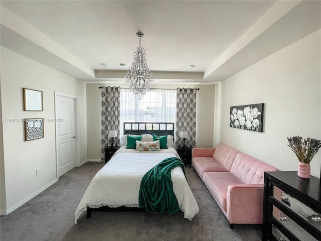 carpeted bedroom featuring a notable chandelier and a tray ceiling