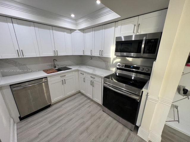 kitchen featuring appliances with stainless steel finishes, white cabinets, and light hardwood / wood-style floors