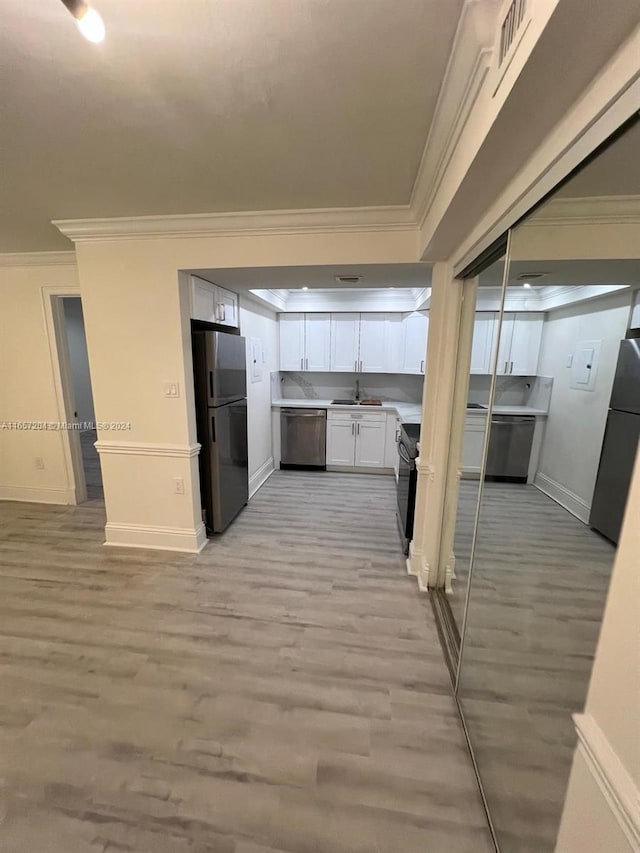 kitchen featuring stainless steel appliances, sink, light wood-type flooring, and white cabinets