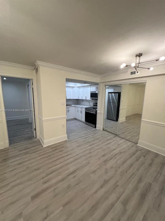 unfurnished living room with hardwood / wood-style floors and ornamental molding