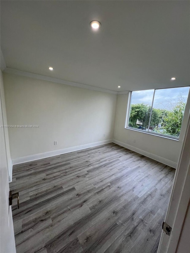 spare room with crown molding and hardwood / wood-style flooring