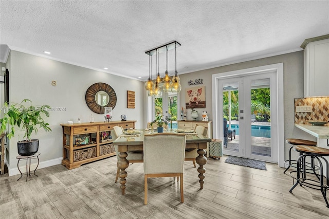 dining room featuring crown molding, french doors, a textured ceiling, and light hardwood / wood-style flooring