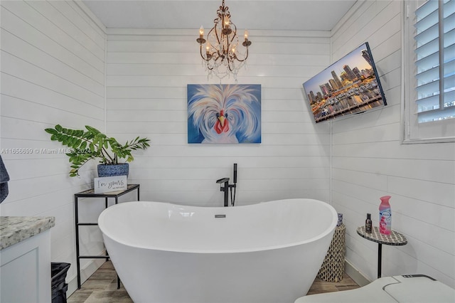 bathroom with wooden walls, vanity, wood-type flooring, and a washtub