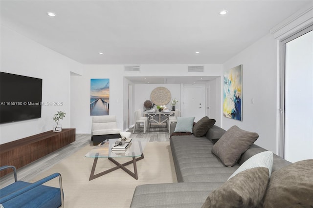 living area with visible vents, wood finished floors, and recessed lighting