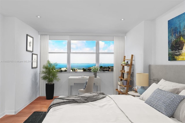 bedroom featuring baseboards, wood finished floors, and recessed lighting