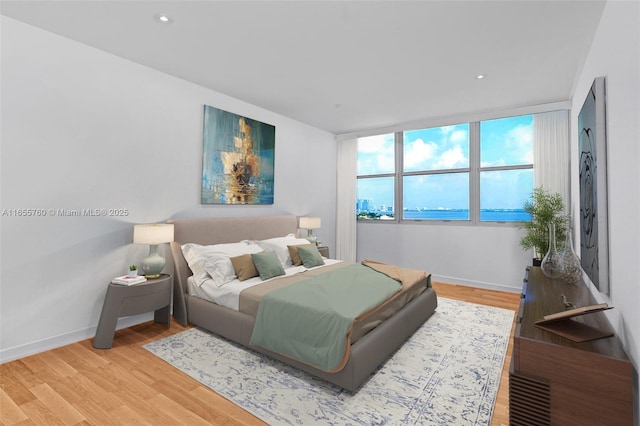 bedroom with baseboards, recessed lighting, and light wood-style floors