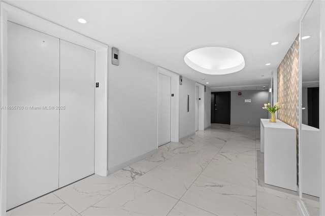 corridor featuring elevator, marble finish floor, and recessed lighting