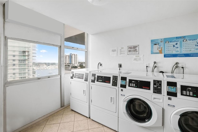 common laundry area featuring light tile patterned floors, washing machine and dryer, and a city view