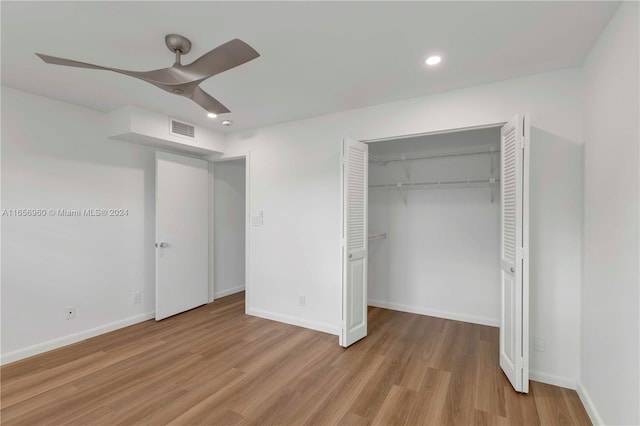 unfurnished bedroom featuring ceiling fan, a closet, and light wood-type flooring