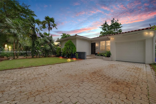 mediterranean / spanish-style house with a yard and a garage