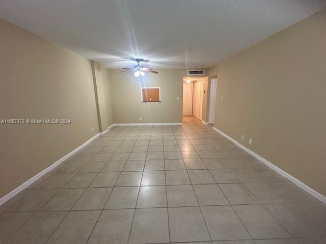 tiled empty room with ceiling fan