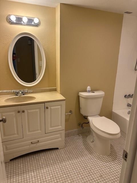 bathroom with toilet, vanity, and tile patterned floors