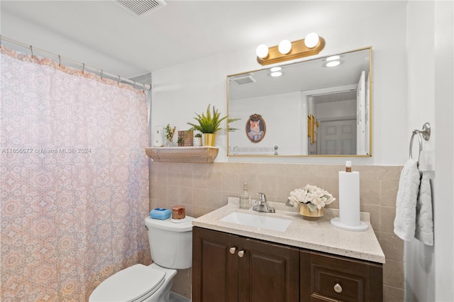 bathroom with tile walls, backsplash, toilet, and vanity