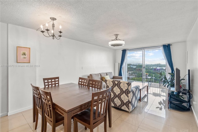 tiled dining space featuring an inviting chandelier and a textured ceiling