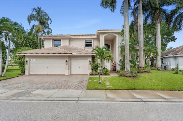 mediterranean / spanish-style home featuring a front yard and a garage