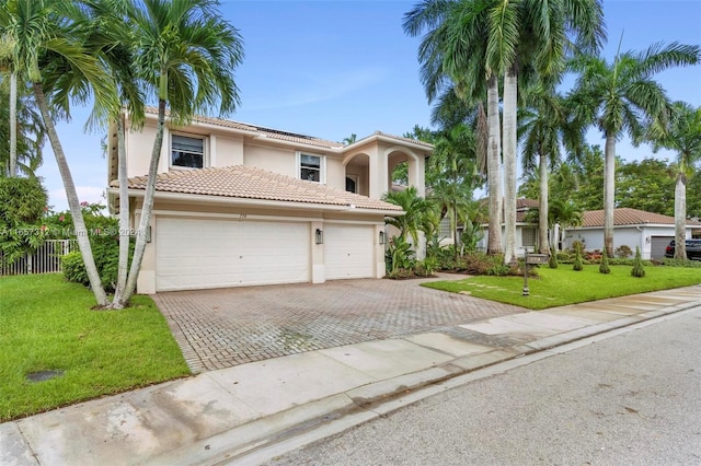 mediterranean / spanish house with a garage and a front lawn