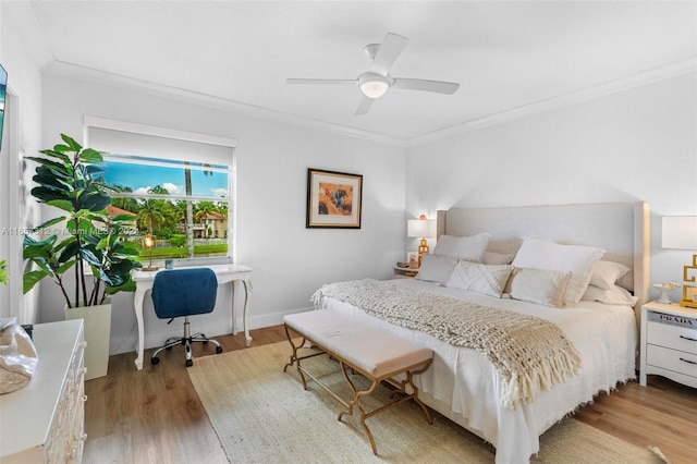 bedroom with crown molding, ceiling fan, and light hardwood / wood-style floors