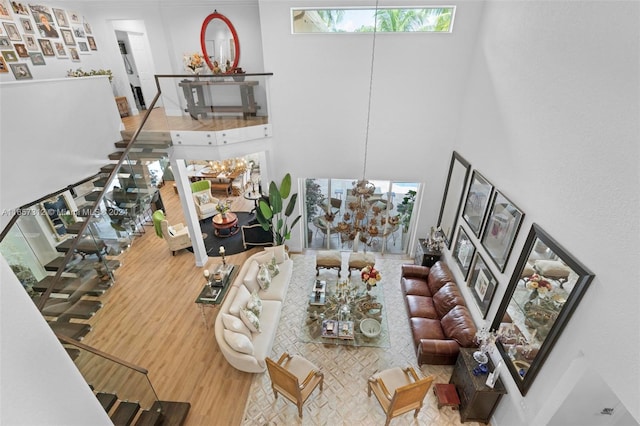 living room featuring a chandelier, light hardwood / wood-style flooring, and a high ceiling