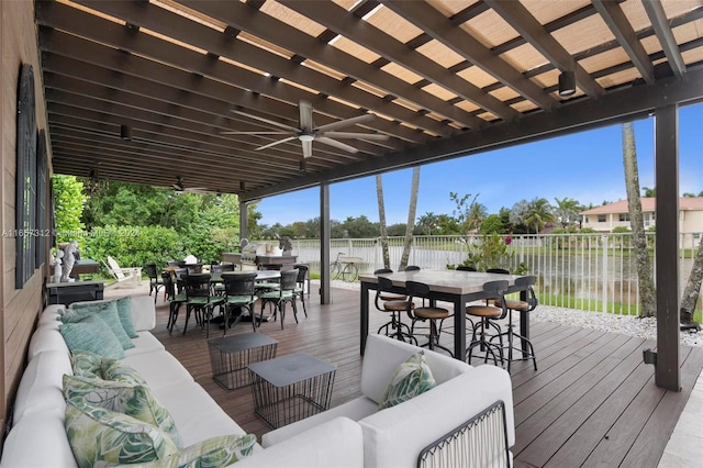 deck with outdoor lounge area, a water view, and ceiling fan