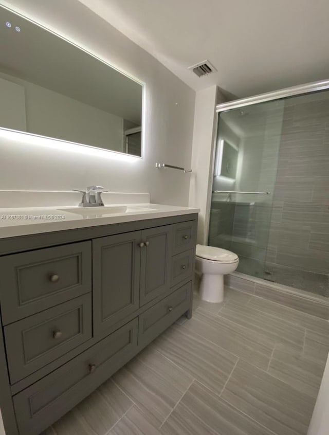 bathroom with vanity, toilet, and an enclosed shower