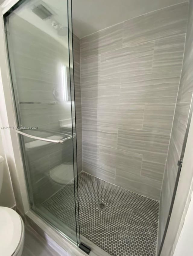 bathroom featuring toilet and an enclosed shower