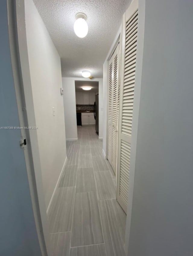 hallway with a textured ceiling