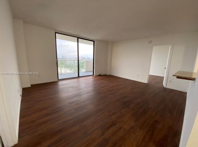 13499 Biscayne Blvd Unit 1507, North Miami, FL 33181 - empty room featuring dark wood-style floors, expansive windows, and baseboards