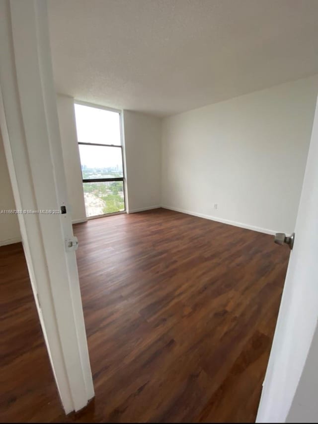 13499 Biscayne Blvd Unit 1507, North Miami, FL 33181 - empty room featuring dark wood-style flooring, baseboards, and expansive windows