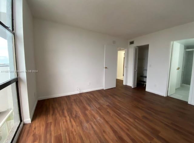 unfurnished room with a wealth of natural light and dark hardwood / wood-style flooring