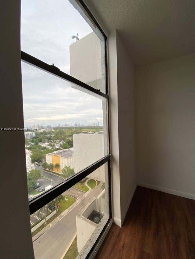 13499 Biscayne Blvd Unit 1507, North Miami, FL 33181 - corridor featuring wood finished floors, baseboards, a city view, and a textured ceiling