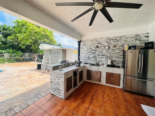 view of patio / terrace with an outdoor kitchen, sink, and ceiling fan