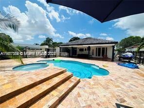 view of pool with a patio and an in ground hot tub