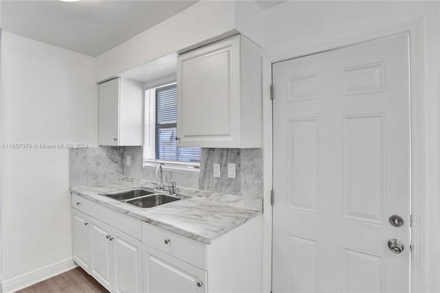 kitchen with white cabinetry, sink, and decorative backsplash