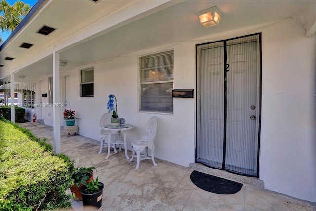 entrance to property with a patio and stucco siding