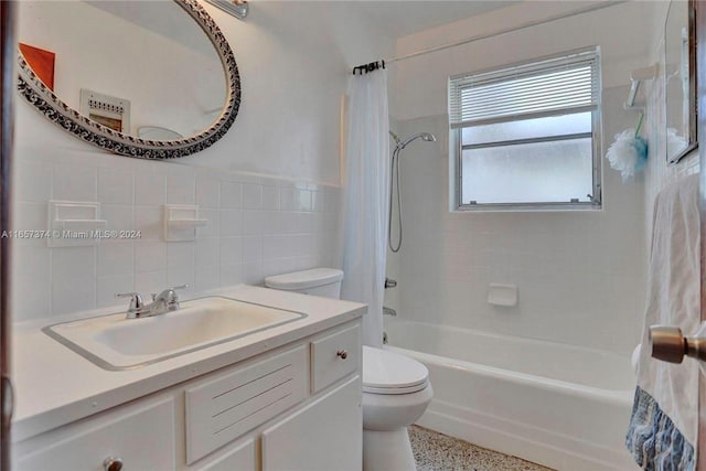 full bathroom with toilet, vanity, backsplash, tile walls, and shower / tub combo with curtain