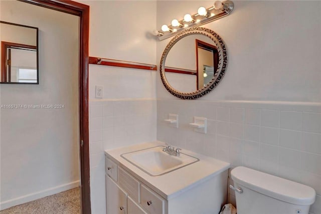 bathroom featuring vanity, tile walls, toilet, and decorative backsplash