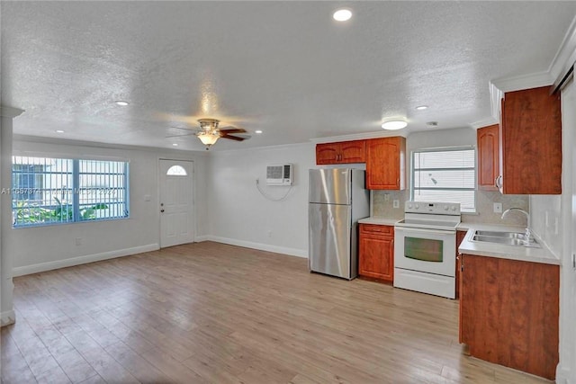 kitchen with a ceiling fan, white range with electric stovetop, a sink, baseboards, and freestanding refrigerator